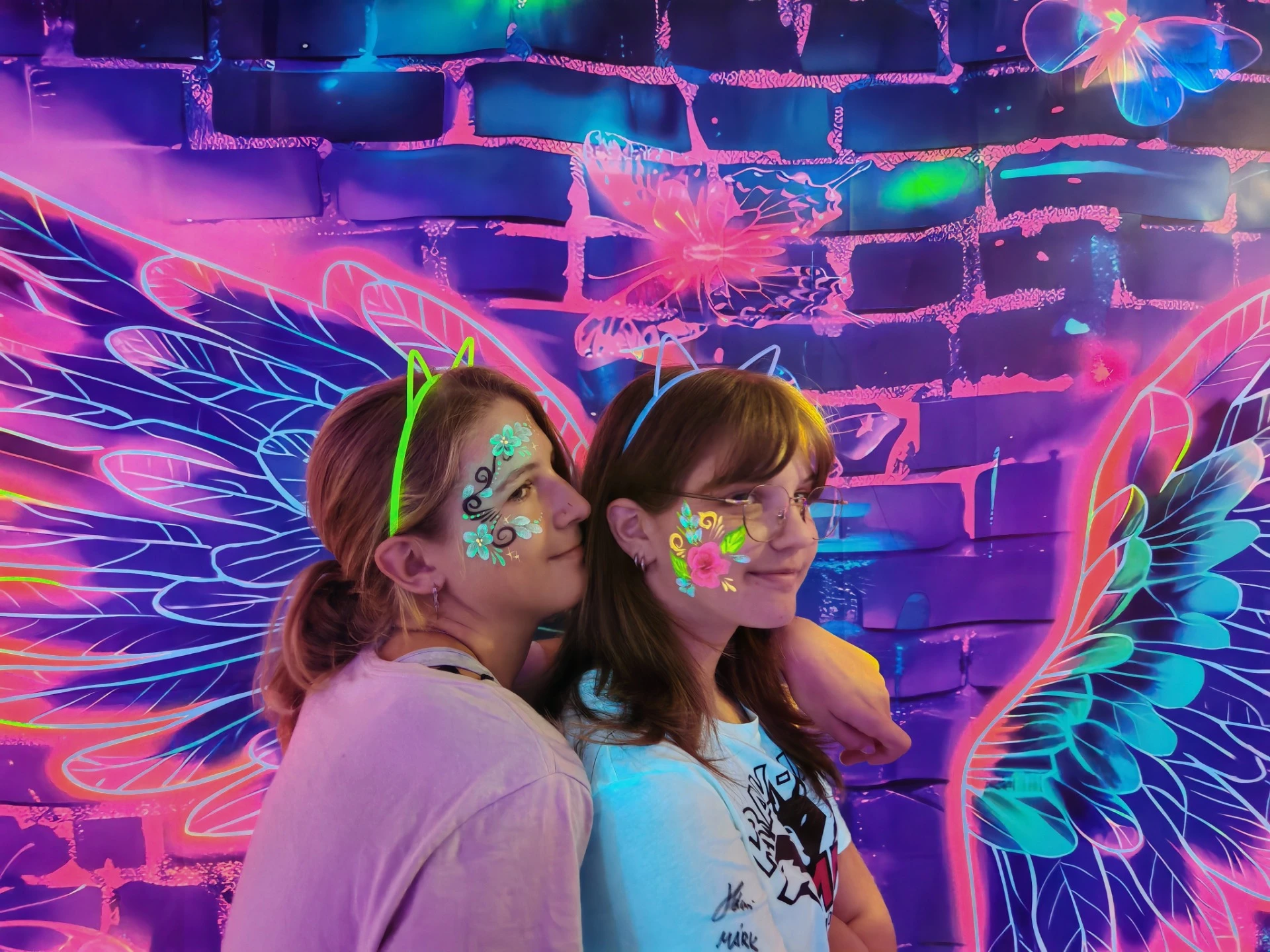 UV fotófal neon szárnyakkal és világító fejdíszekkel